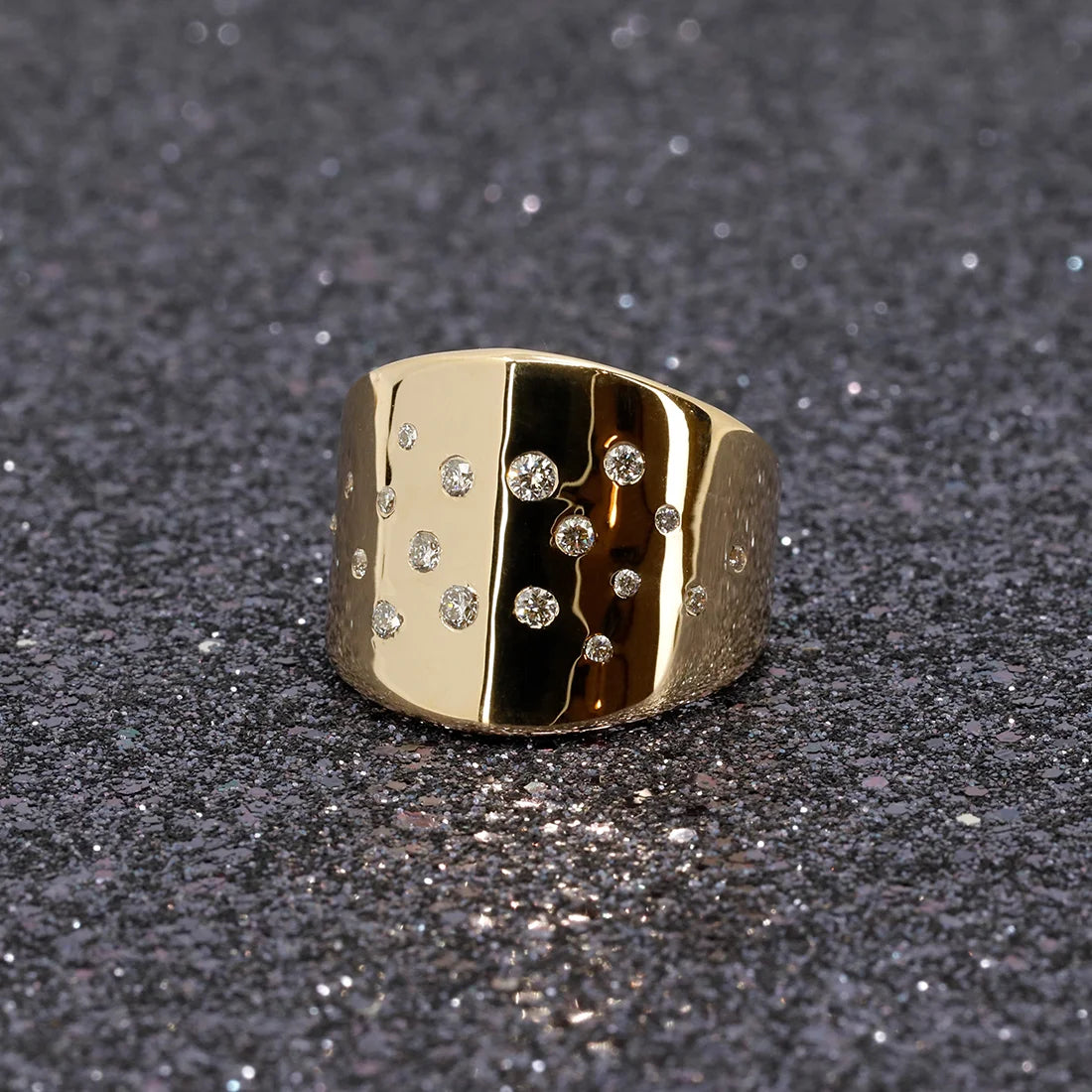 Front view of the Yellow gold and diamond statement ring photographed with a glamorous glitter backdrop, designed in Montreal by Bena Jewelry.