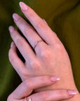Cose-up of a woman’s hand wearing the Kink white gold open diamond ring, showcasing its edgy and modern design with natural brilliant diamonds by Bena Jewelry, made in Montreal.