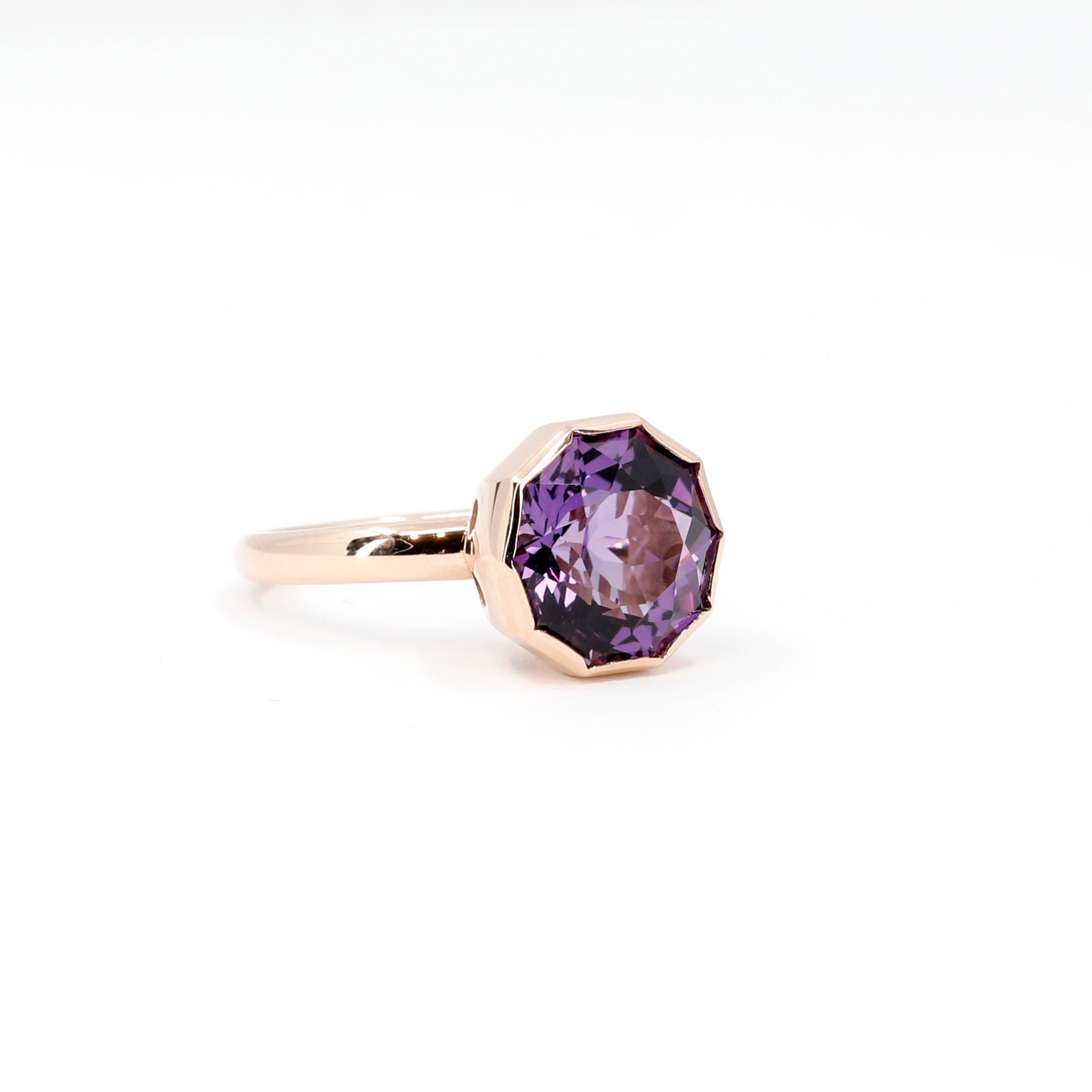 Side view of a coktaol yellow gold ring with a natural Brazilian amethyst, displayed from a unique angle on a clean white background.