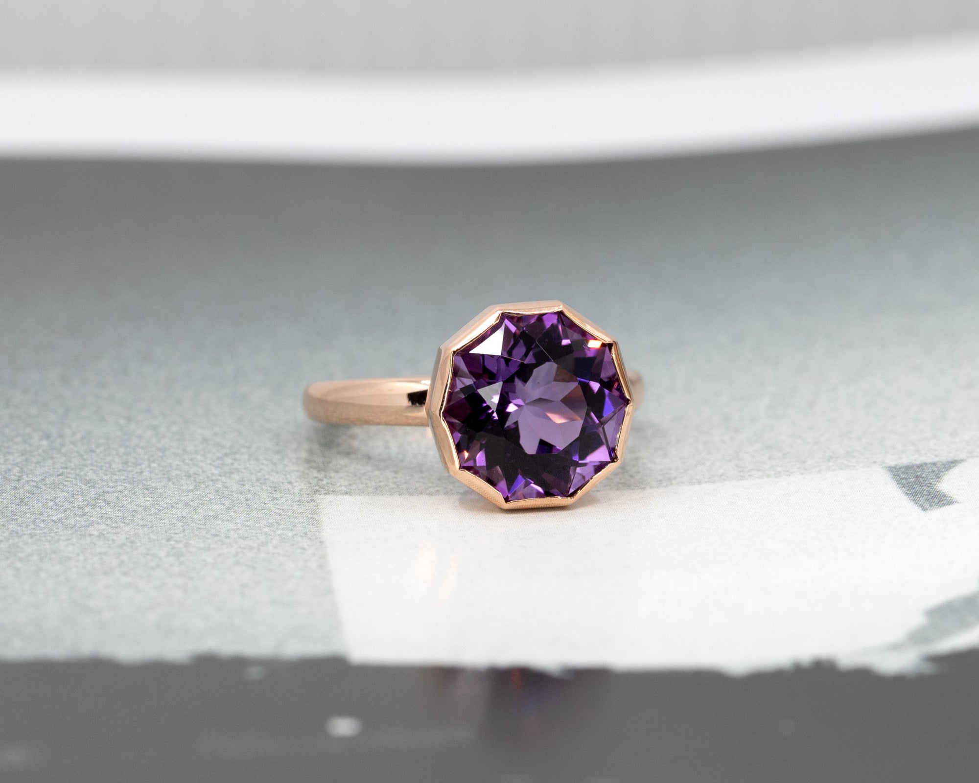 Bijou Round Fancy Amethyst Ring, part of the Fancy Edgy Collection, featuring a unique bold design, photographed on a grey surface.