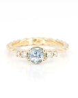 Top view: Showcasing the round aquamarine centerpiece and the diamonds on the braided yellow gold band. Made by Bena Jewelry in Montreal, Canada.
