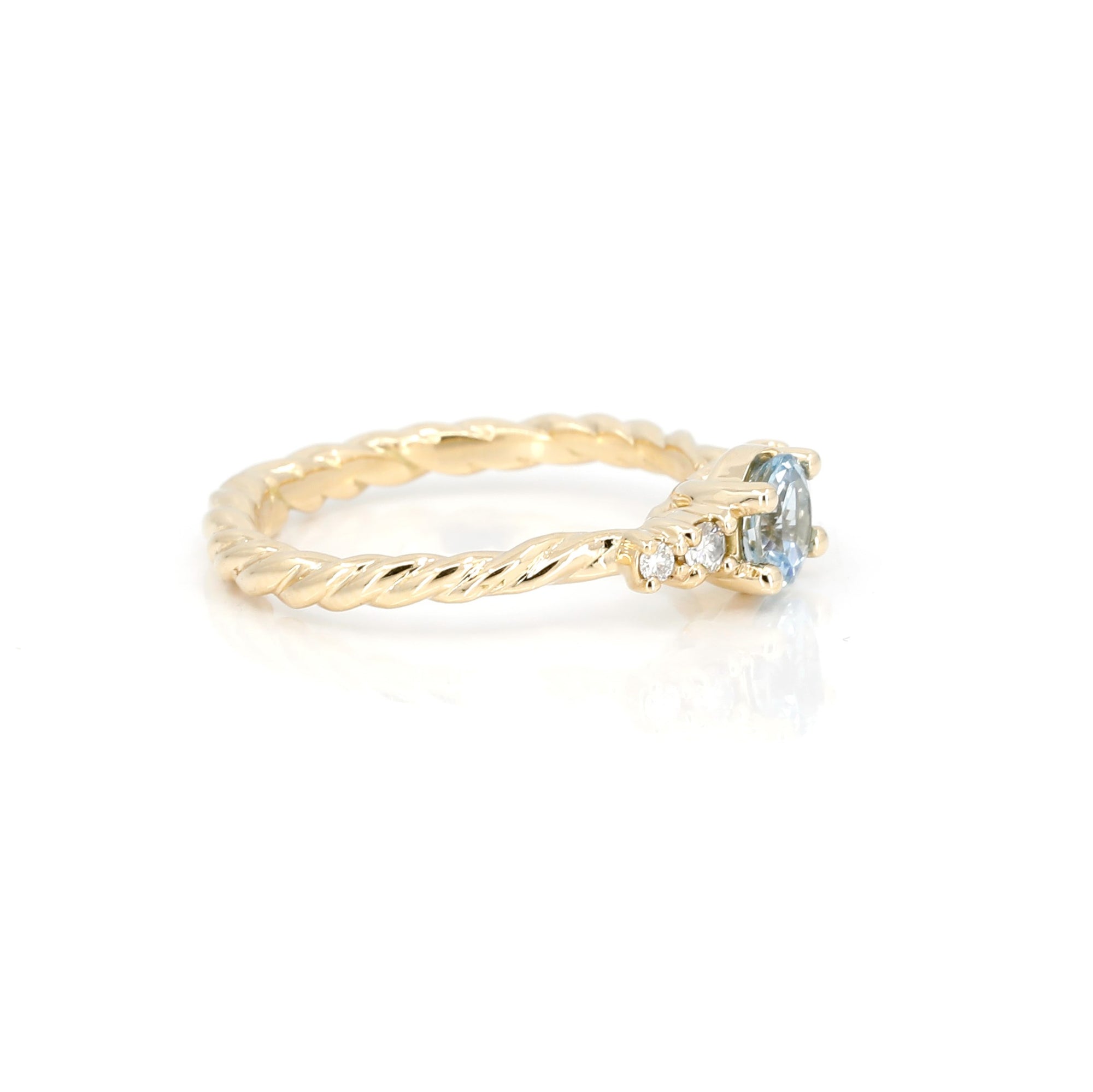 Close-up: Captures the delicate craftsmanship of the aquamarine setting and the polished yellow gold finish. Designed in Montreal, Canada by independent jeweler Bena Jewelry.