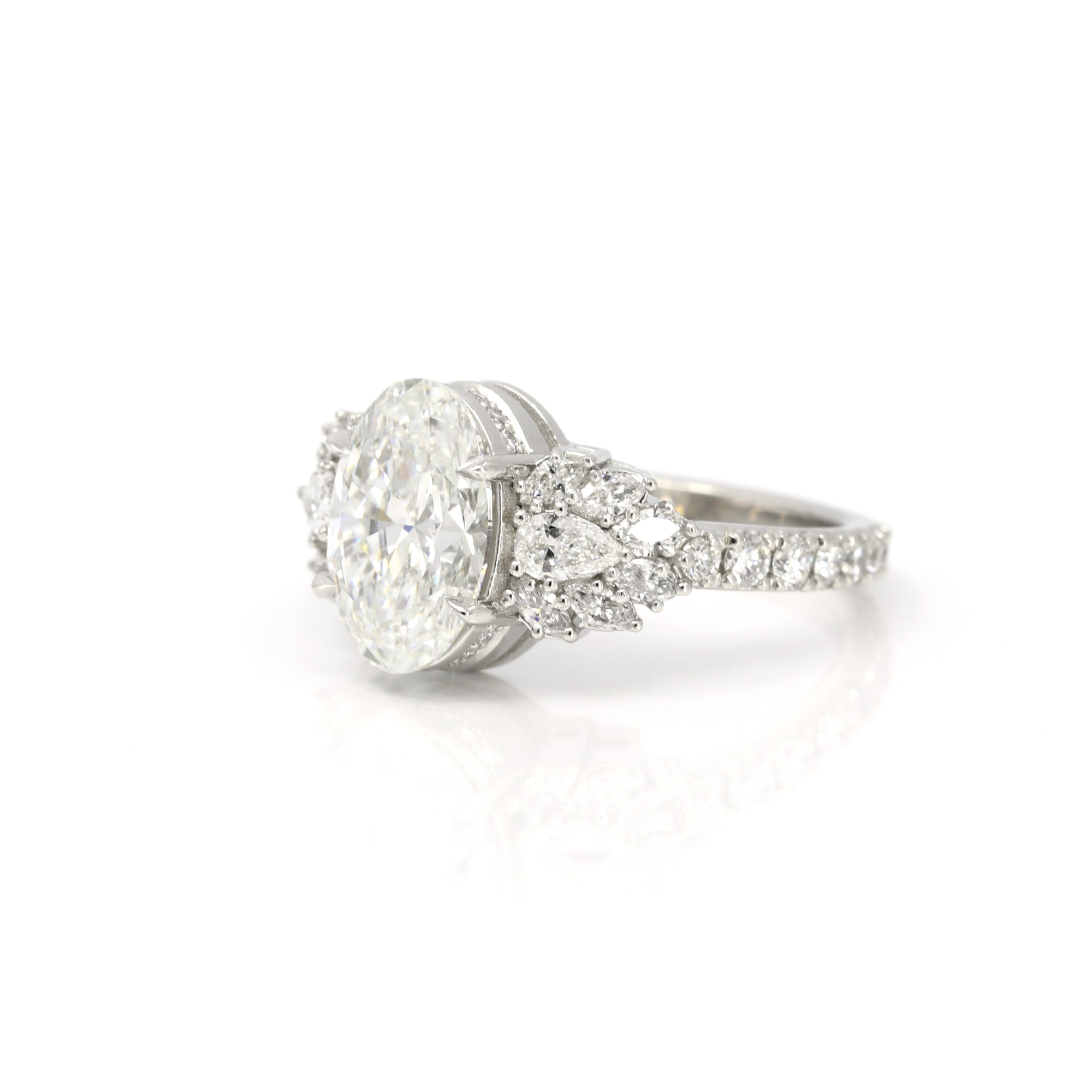 side view of oval shape lab grown diamond made in montreal with design marquise shape and peat natural gemstone with platinum bespoke jewellery design on white background