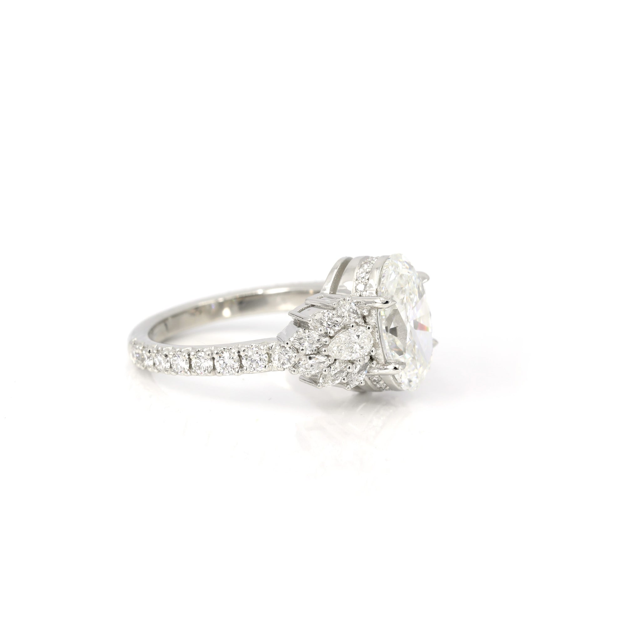 side view of diamond engagement ring custom made in montreal by bena jewelry bridal ring designer with natural round pear and marquise gemstone custom made at boutique ruby mardi best jewellery store in canada on white background