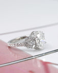 side view of bridal diamond engagement ring made in montreal by the best bena jewelry designer with central oval shape lab grown diamond and side marquise and pear shape icy gemstone on multi color background