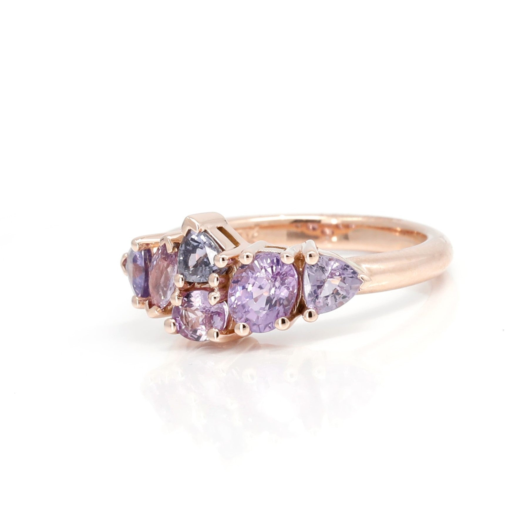 The "Avalanche" ring in 14k rose gold adorned with lilac and purple sapphires, displayed on a white background to highlight the intricate gemstone details and the asymmetrical design. Contemporary jewelry made in Montreal by Bena Jewelry.