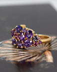 Top-down view: Displays the unique sapphire design and the harmonious blend of purple tones with the yellow gold. Made by Bena Jewelry, Montreal, Canada.