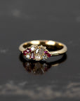 Ruby & Salt And Pepper Diamond Avalanche Ring with rubies and diamonds set in yellow gold, shot against a dark background to highlight its striking design.