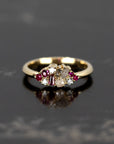 Elegant Ruby & Salt And Pepper Diamond Avalanche Ring on a dark background, featuring a unique arrangement of rubies and diamonds in yellow gold.