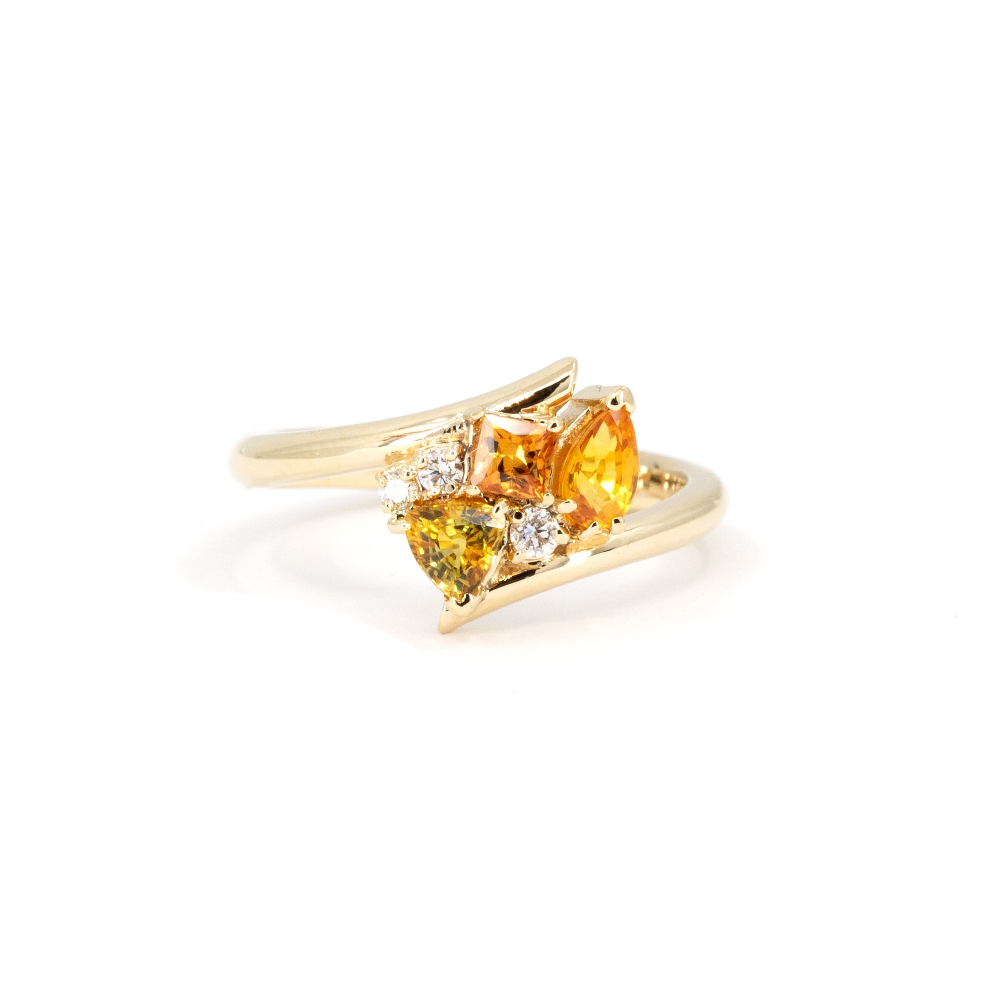 Front view of the Kink Avalanche ring showing off the bold twist design and vibrant sapphires with diamonds, handcrafted in yellow gold by Bena Jewelry.
