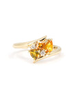 Front view of the Kink Avalanche ring showing off the bold twist design and vibrant sapphires with diamonds, handcrafted in yellow gold by Bena Jewelry.