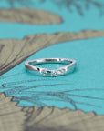 Curved diamond band by Bena Jewelry, displayed against a soft blue background, featuring three diamonds in a smooth, modern curve design.