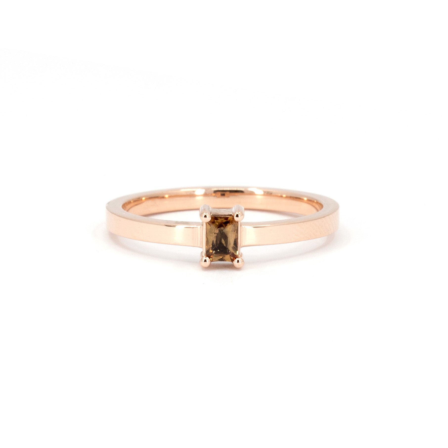 Rose gold ring featuring an orange sapphire and matching diamond band by Bena Jewelry, displayed on a white background.