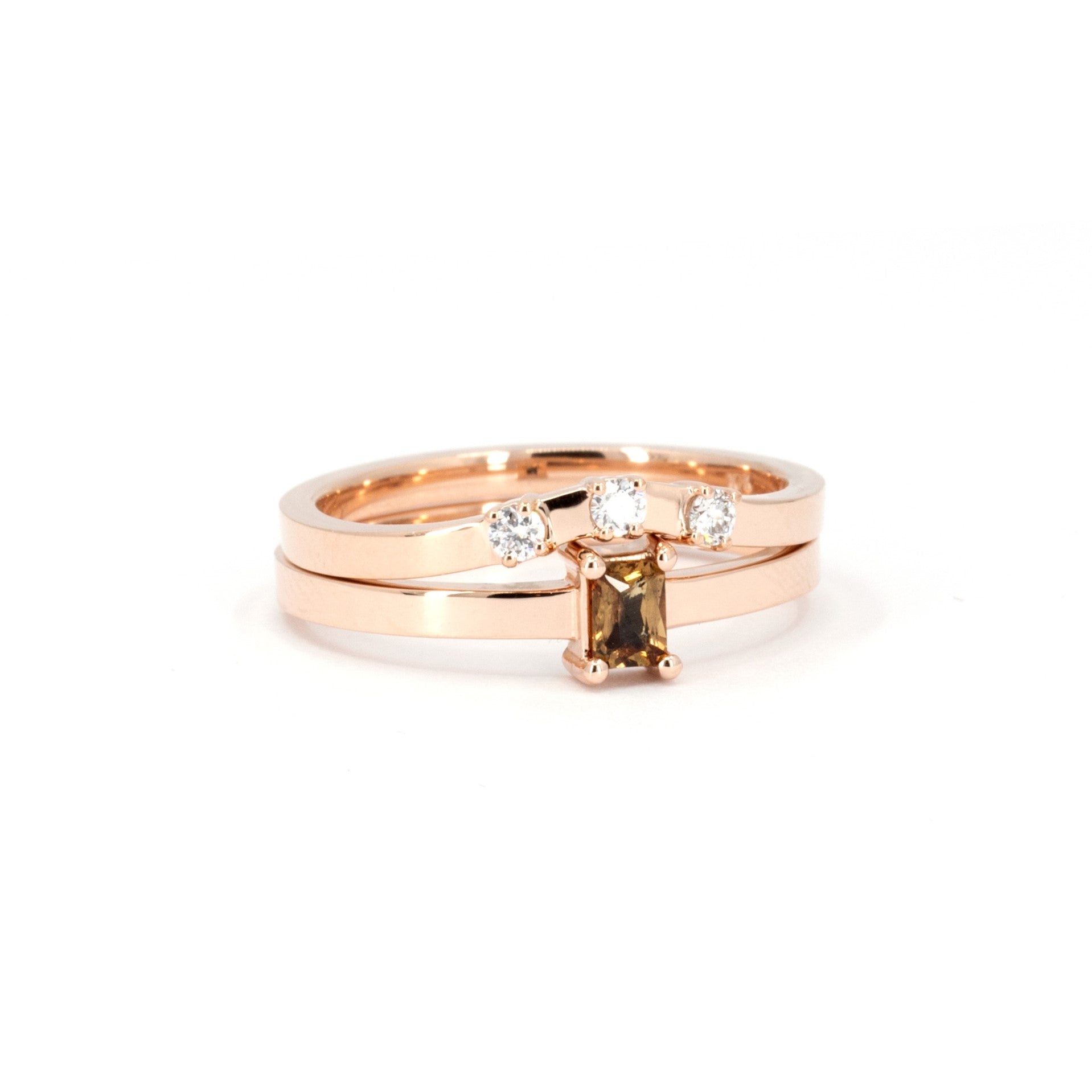 Close-up of Bena Jewelry's rose gold ring with an orange sapphire and diamond accents, set against a white background.