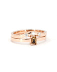 Close-up of Bena Jewelry's rose gold ring with an orange sapphire and diamond accents, set against a white background.