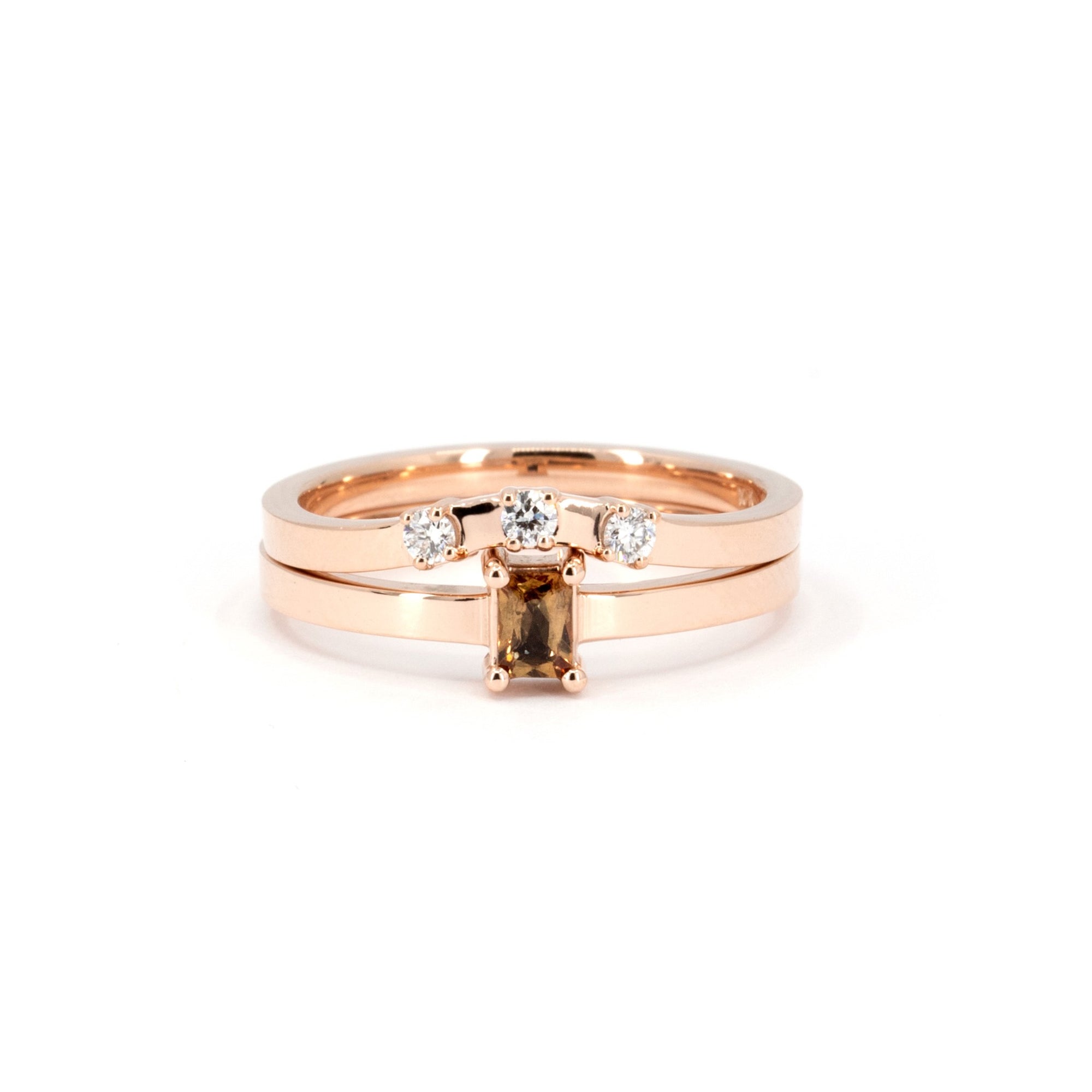 Rose gold ring featuring an orange sapphire and matching diamond band by Bena Jewelry, displayed on a white background.