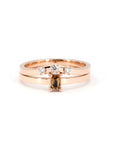 Rose gold ring featuring an orange sapphire and matching diamond band by Bena Jewelry, displayed on a white background.