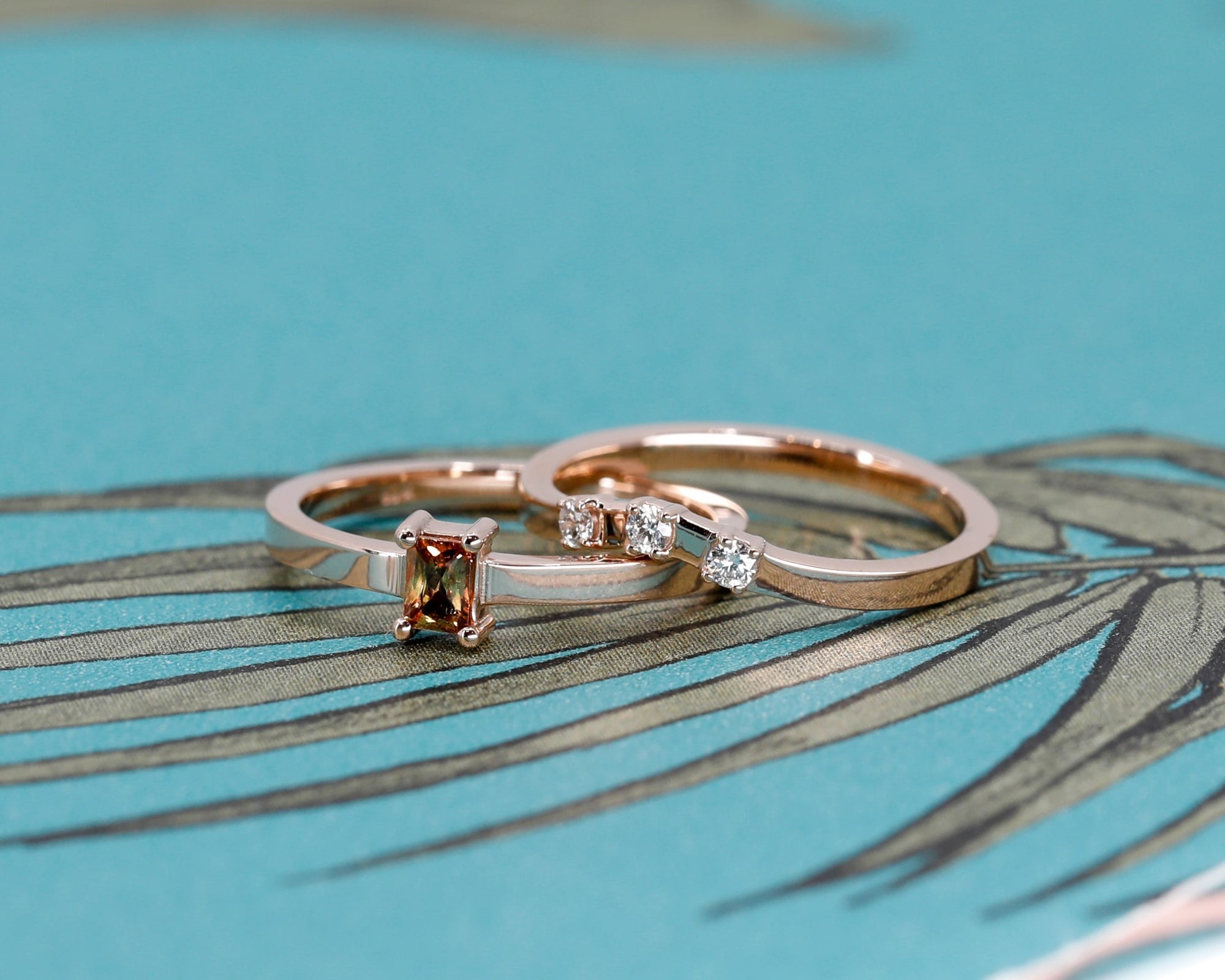 Detailed view of Bena Jewelry's rose gold diamond band, complementing the orange sapphire ring, on a white background.