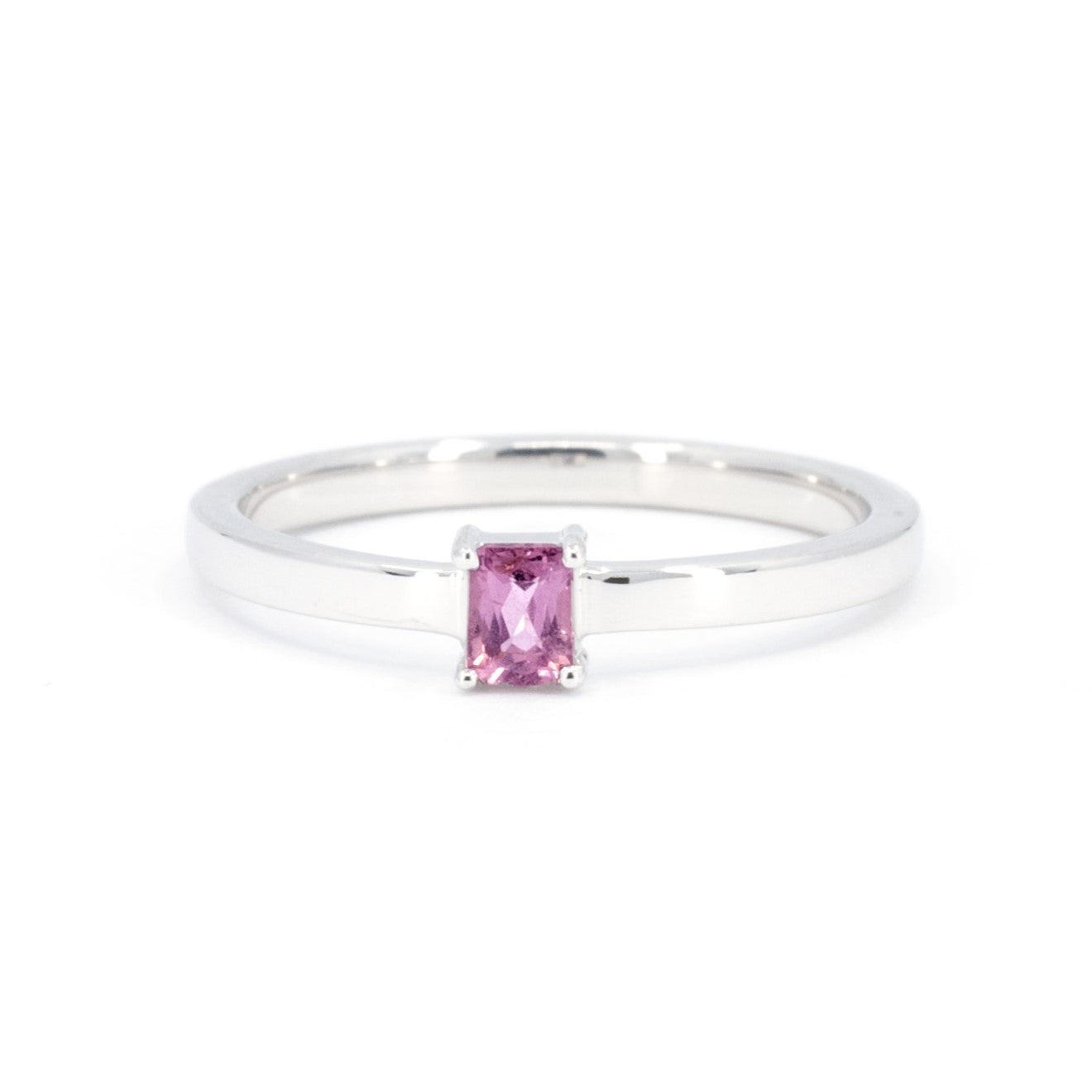 White gold ring with a baguette-cut pink sapphire, featuring an edgy and modern design by Bena Jewelry in Montreal, Canada.