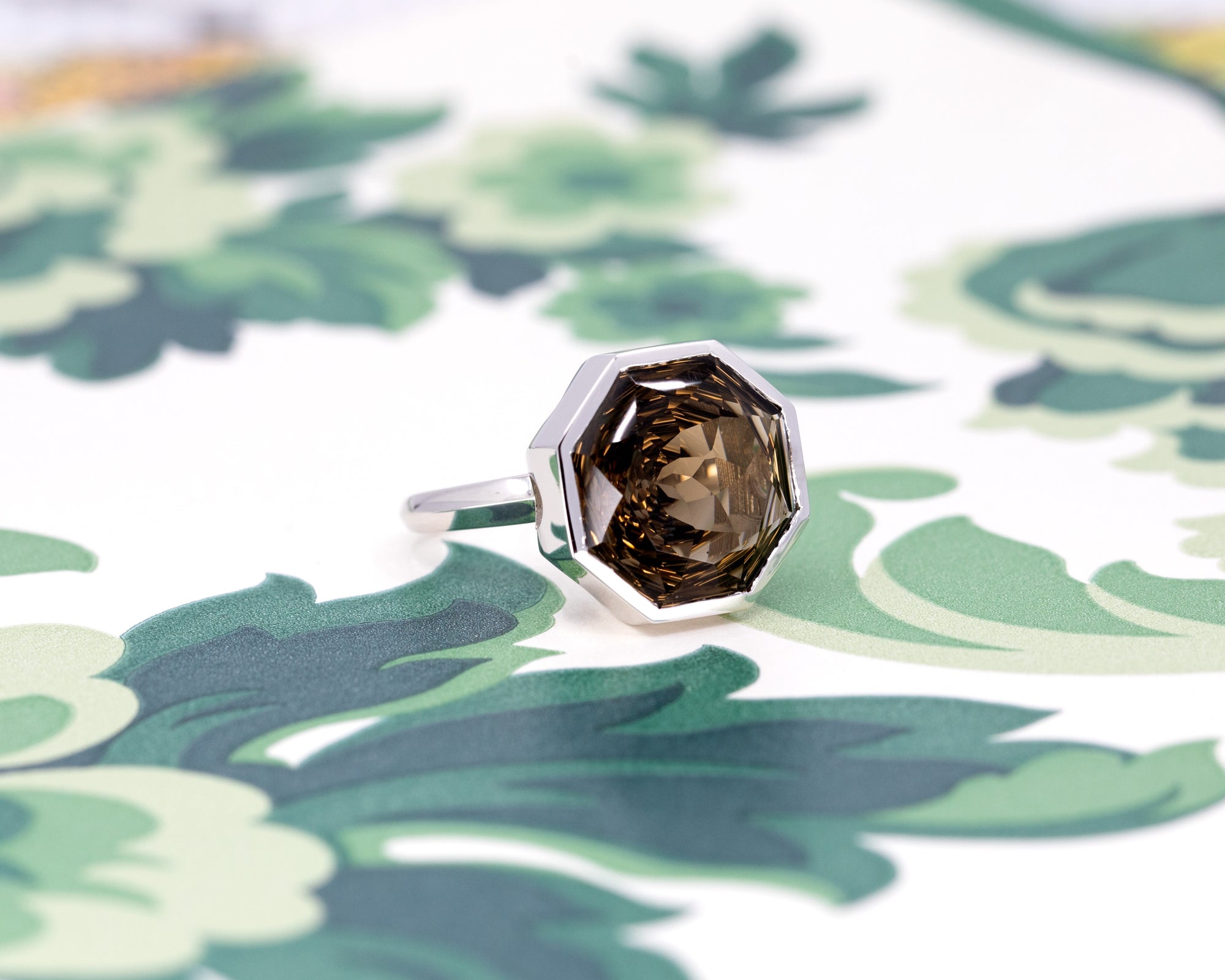 Side view of Bijou White Gold Smoky Quartz Ring, featuring a unique design and generous gold volume, photographed on a colorful surface.