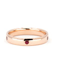 Men's rose gold wedding band with bezel-set pigeon blood rubies and a subtle dome, crafted by Bena Jewelry in Montreal, Canada.
