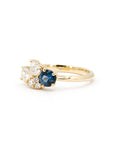 Side profile of a yellow gold ring featuring a blue spinel and diamonds, handcrafted by Bena Jewelry.
