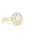side view of lab grown diamond halo and central round shape gemstone yellow gold designer bridal ring made in montreal by bena jewelry on white background