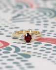 Close-up of engagement ring on dark background – The vibrant ruby and diamonds contrast beautifully with the dark setting.