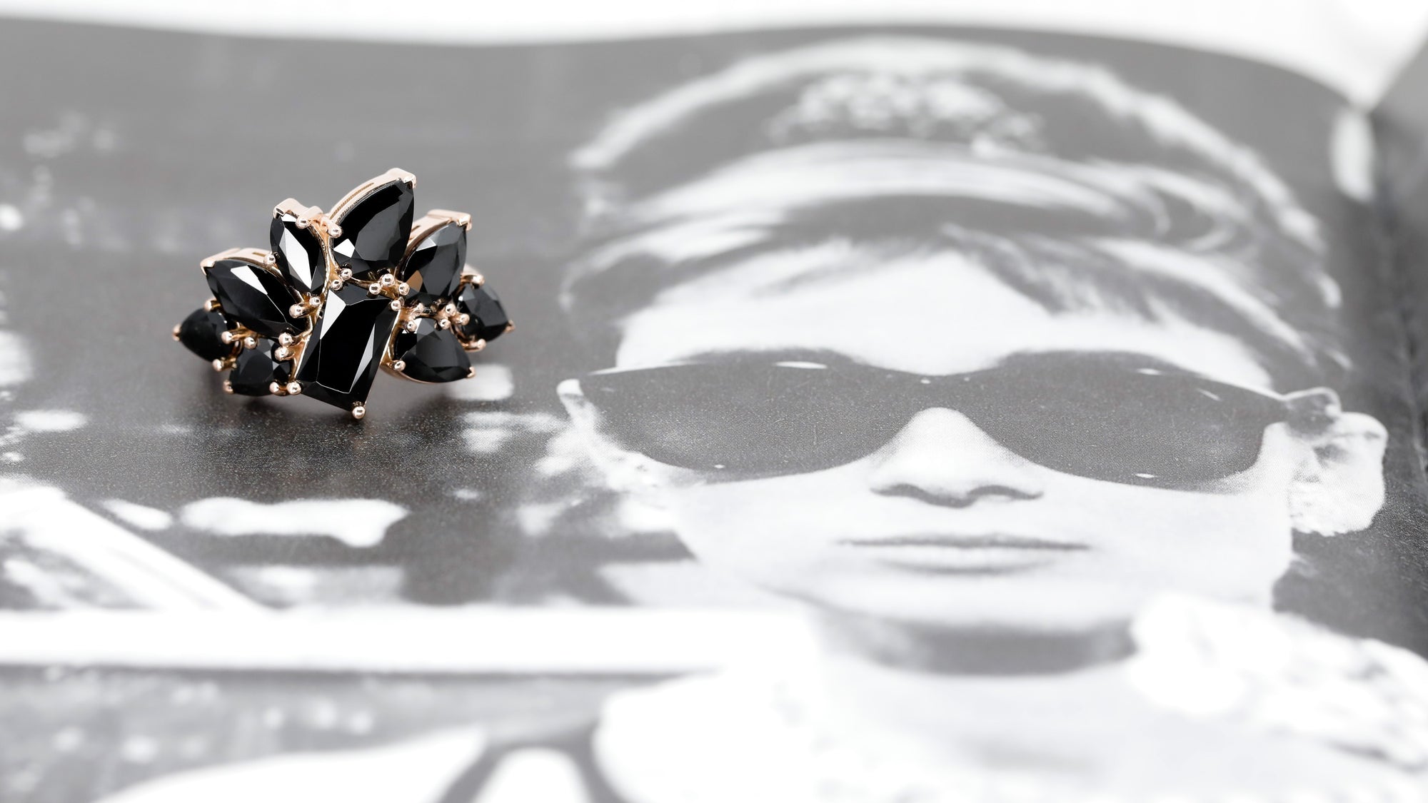 Bena Jewelry presents The Black Trombone Ring set against a deep background, showcasing the brilliance of the rose gold and the unique textures of the black tourmalines.