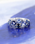 Front view: The Avalanche Blue Sapphire Ring against a dark background, emphasizing the contrast between the vibrant blue sapphires and the sleek white gold. Designed by Bena Jewelry in Montreal, Canada.