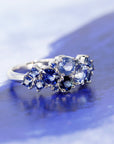 Side view: Highlights the depth and detail of the sapphire arrangement and the polished finish of the white gold band. Crafted by Bena Jewelry in Montreal, Canada.