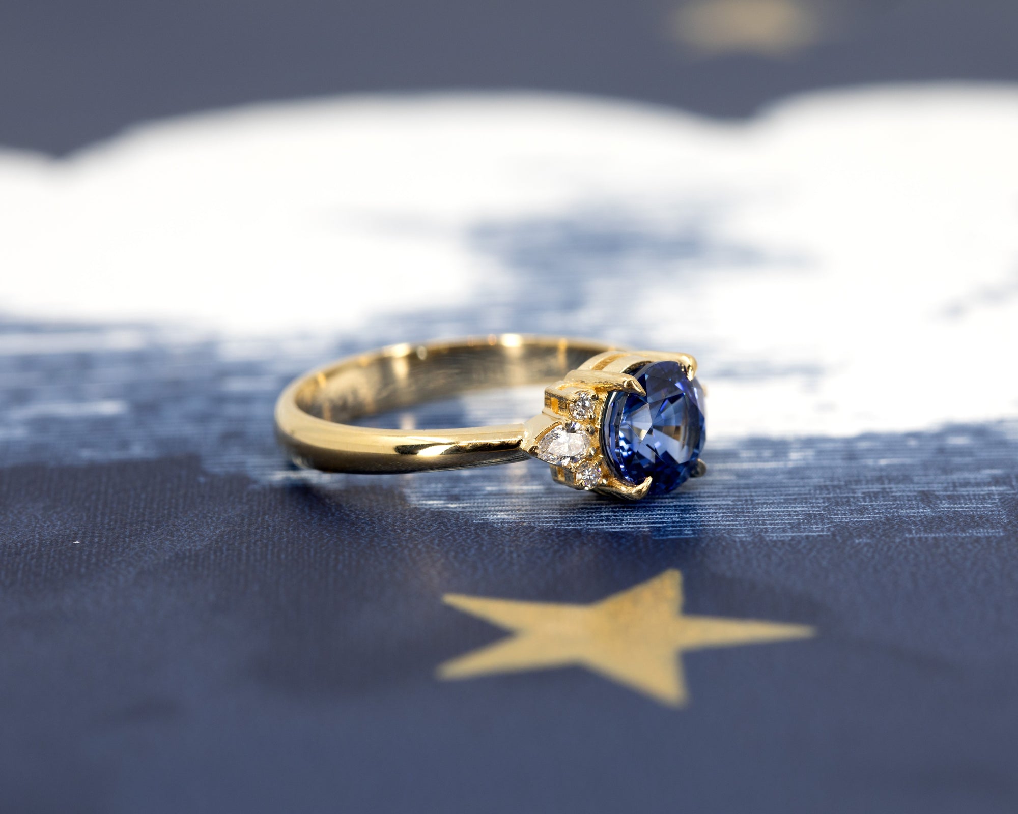 Angled shot of Azure Tide Sapphire & Diamond Ring – A refined engagement ring with an artistic arrangement of pear and round diamonds.