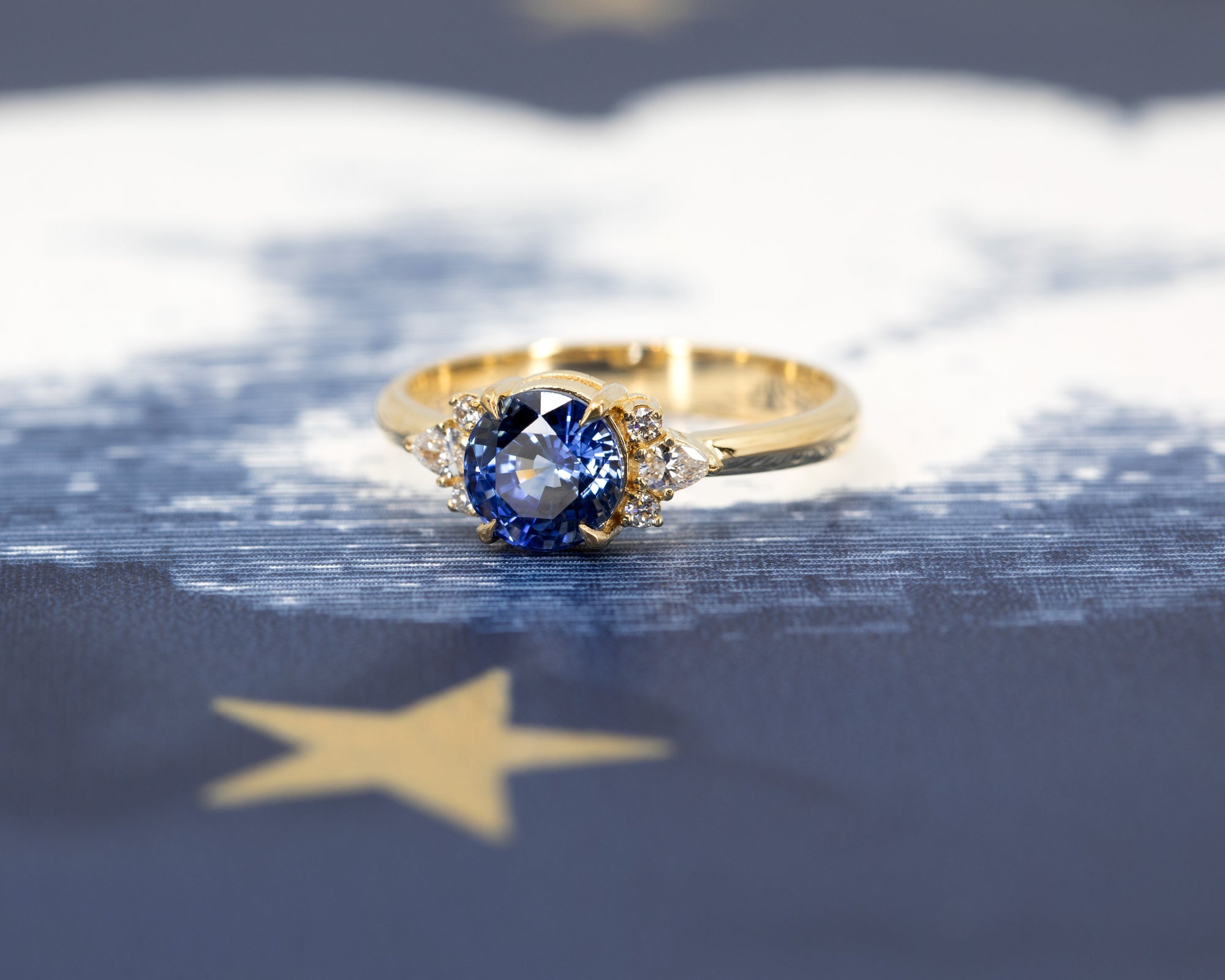 Side view of Azure Tide Sapphire & Diamond Ring – A handcrafted engagement ring showcasing a round blue sapphire and elegant diamond accents.