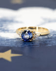 Close-up of Azure Tide Sapphire & Diamond Ring – A striking fine jewelry piece with a rich yellow gold setting and brilliant-cut side diamonds.