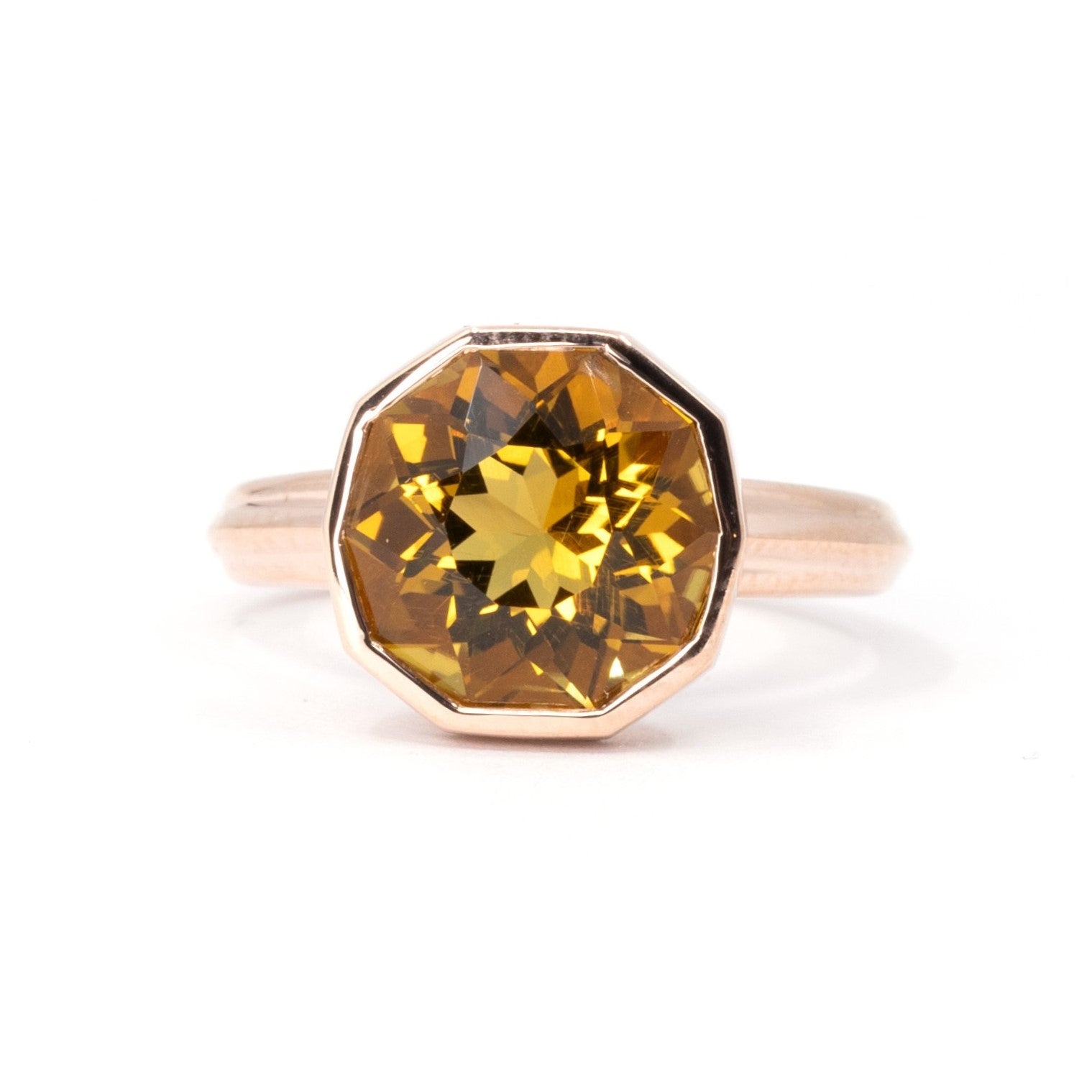 Octagonal orange citrine ring in yellow gold, bezel-set with a modern design by Bena Jewelry displayed on a white background.