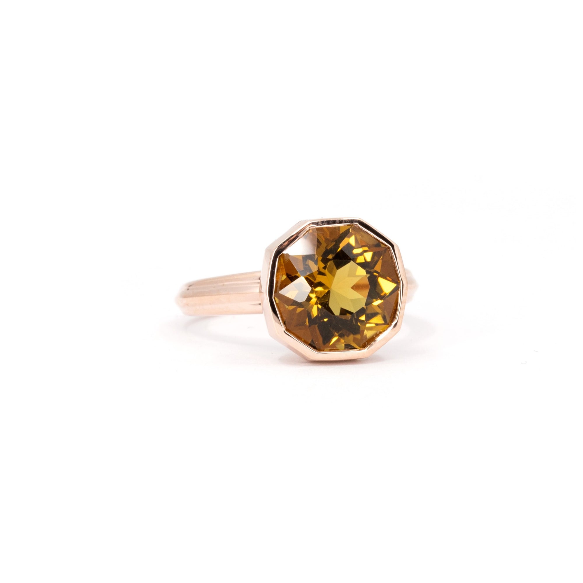 Side view of the statement yellow gold Bijou citrine ring by Bena Jewelry Montreal, photographed white surface.