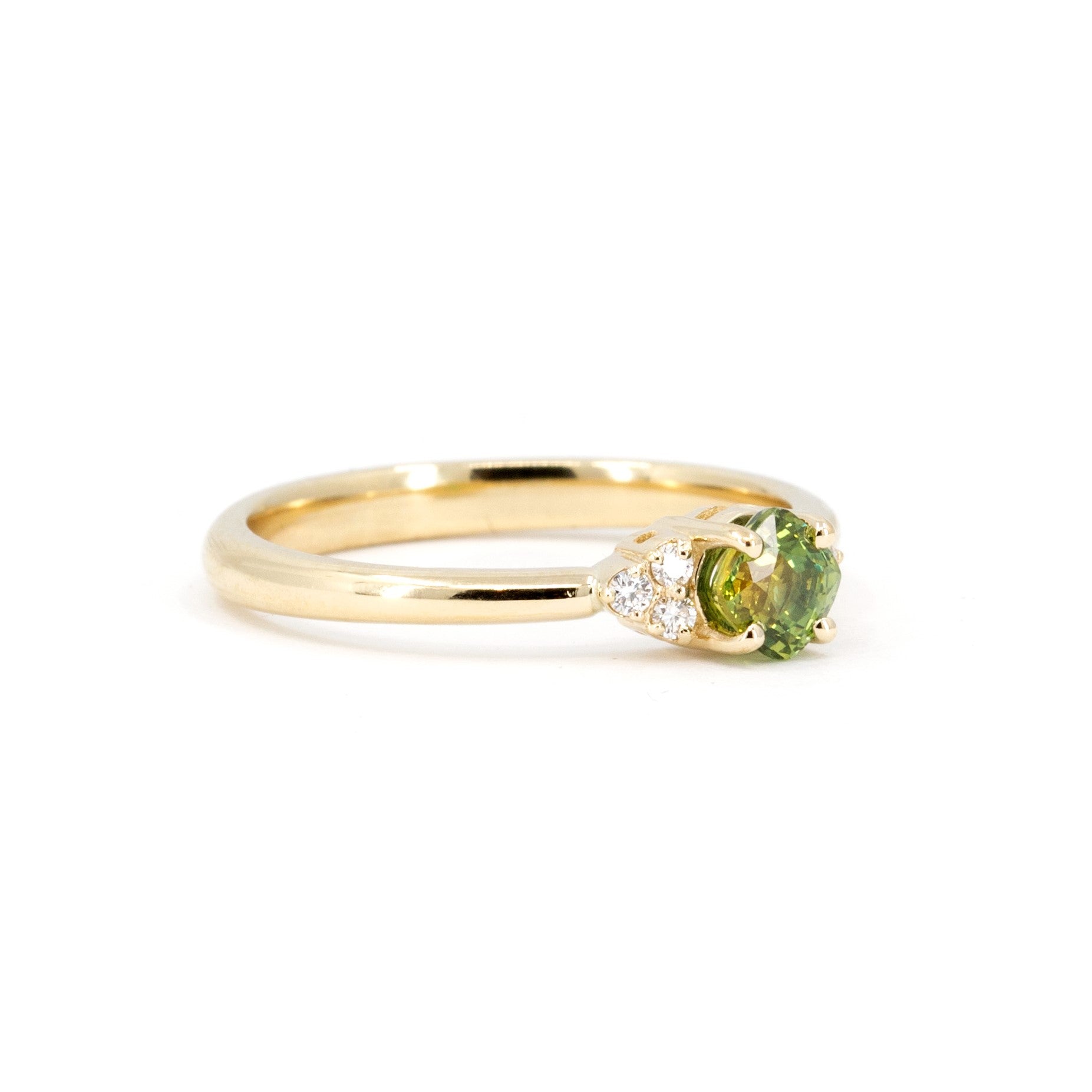 Side view of a timeless green sapphire engagement ring with diamonds. Handcrafted in Montreal by Bena Jewelry, a Canadian jewelry designer.