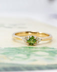 Yellow gold engagement ring featuring a natural cushion-cut green sapphire and diamonds. Designer bridal jewelry made in Montreal by Bena Jewelry.