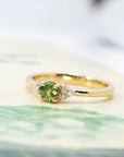 Elegant green sapphire ring with a cushion-cut gemstone and sparkling side diamonds. A modern and refined engagement ring by Bena Jewelry, crafted in Montreal.