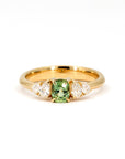 Cushion-cut green sapphire ring with lab-grown pear-shaped diamonds, set in yellow gold. Made by Bena Jewelry, Montreal, Canada.
