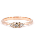 Custom engagement ring by Bena Jewelry, featuring a golden champagne diamond with round side diamonds. Set on a rose gold band, displayed on a clean white background. A timeless design crafted in Montreal.