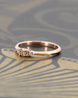Bena Jewelry’s custom rose gold engagement ring with a golden champagne diamond and sparkling side stones. Photographed on a dark matte surface for a bold and luxurious look. Designed and crafted in Montreal.
