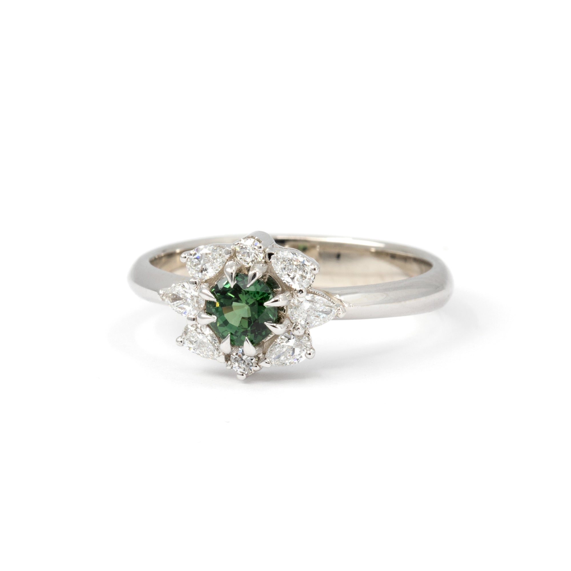 Side view of the Deep Forest Glow ring in 10k white gold, showcasing the intricate setting of the green sapphire and the detailed craftsmanship of the diamond arrangement.