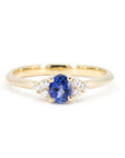 Desir Ring with an oval blue sapphire and diamond accents, set in yellow gold. A handcrafted engagement ring by Bena Jewelry, Montreal.