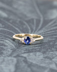 Artistic shot of the Desir Ring with a deep blue sapphire and diamonds, set in yellow gold, crafted by Bena Jewelry in Montreal.