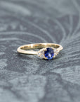 The Desir Ring, a custom sapphire and diamond engagement ring, beautifully displayed on a soft-colored surface. Designed in Canada.