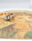 Désir Baguette Green Sapphire Ring in rose gold featuring a baguette-cut sapphire and diamonds by Bena Jewelry photographed on a dark background bespoke bridal jewelry made in Montreal
