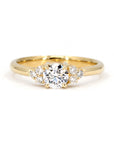 Yellow gold engagement ring featuring a central round diamond and side stones, custom-made by Bena Jewelry in Montreal, Canada. Timeless fine jewelry.