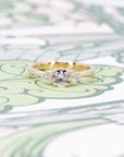 Elegant round diamond engagement ring in yellow gold with sparkling side stones, handmade by Bena Jewelry in Montreal.