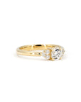 Classic yellow gold engagement ring with a central diamond and side accents, designed by Bena Jewelry, a Montreal-based jewelry designer.